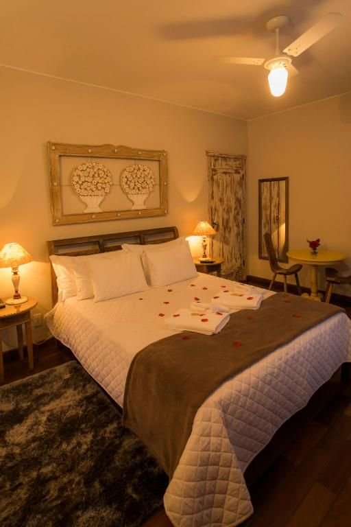 Cama com pétalas de rosas e toalhas bordadas